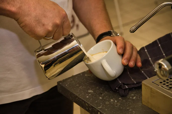 Präzision beim Latte-Art-Guss Cremigen Milchschaum gießen für Latte Art beim Kaffeeworkshop von Hausgeräte Siegerland in Freudenberg